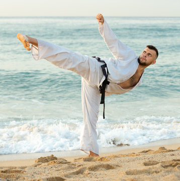 Glad male practising karate kata poses