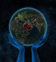 Saudi Arabia on night Earth in hands