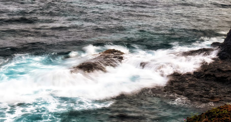 Waves crashing over the rocks in the surf at Rollas island in Sao tome and Principe