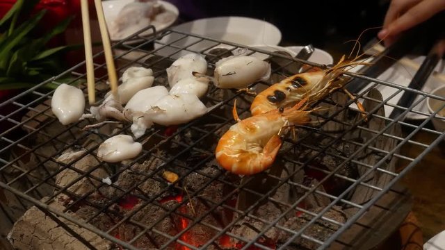Grilled shrimps on stove grille , cooking barbecue seafood with spicy sauce