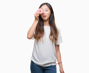 Young asian woman eating donut over isolated background scared in shock with a surprise face, afraid and excited with fear expression