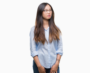 Young asian business woman wearing glasses over isolated background smiling looking side and staring away thinking.