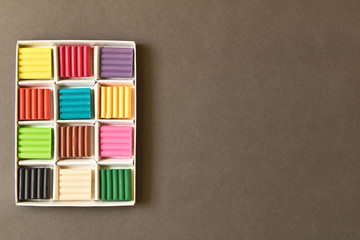 Pieces of children's clay on the background of the blackboard. The concept of education