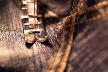 Repair jeans on the sewing machine. View of the fabric, needle and thread. Illumination from the...