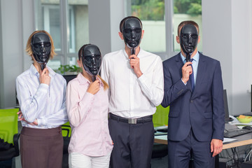 Group of four office employees with closed black face masks. Without a personal staff. People hypocrisy concept.