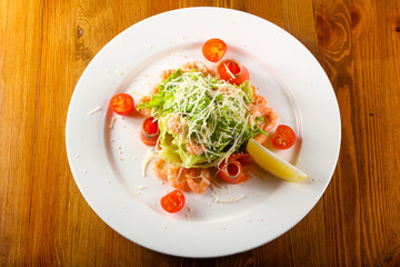 Caesar salad with shrimps and salmon