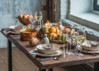 Table setting for Thanksgiving. Autumn table with pumpkins and candles in the center