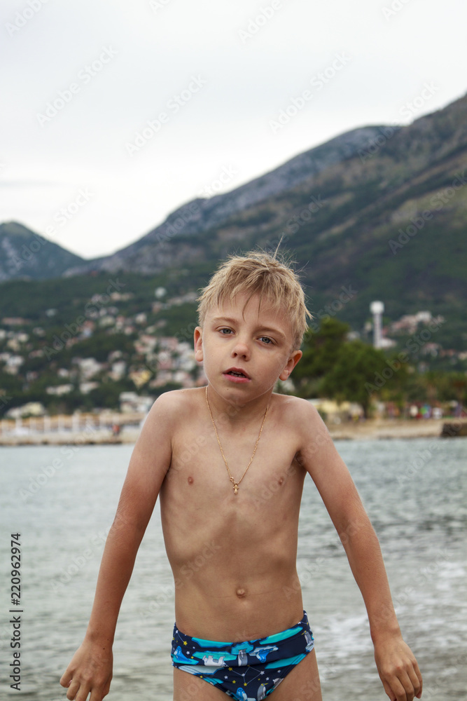 Wall mural little blond boy came out of the sea to the shore, was cold and really creepy