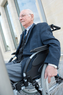 happy old man on wheelchair outdoors