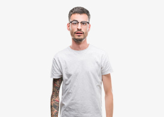 Young tattooed adult man afraid and shocked with surprise expression, fear and excited face.