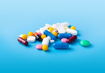 Medicine pills, tablets and capsules over blue background
