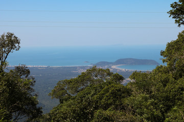 Beautiful panoramic view of green tropical forest, blue sky and beach of Bertioga city in the background - Atlantic Forest in Brazil