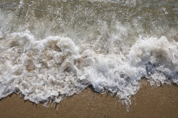 
    Soft wave of turquoise sea water on the sandy beach.