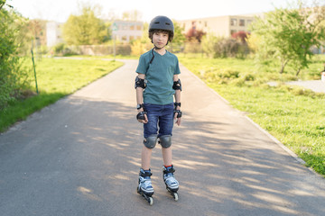 Portrait of a boy on rollers in a protective helmet, knee pads and elbow pads.