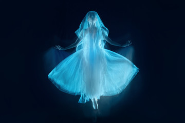 The photo as art - a sensual and emotional dance of beautiful ballerina through the veil on a dark...