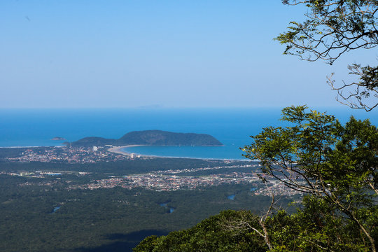 Beautiful panoramic view of green tropical forest, blue sky and beach of Bertioga city in the background - Atlantic Forest in Brazil
