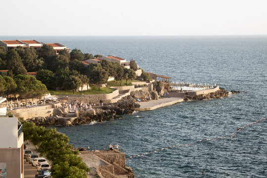 DOBRA VODA, MONTENEGRO - JUNE 20, 2018: top view of the illuminated by the setting rays of the sun the beach on the Adriatic sea in the town of Dobra Voda, Montenegro