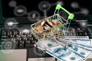 Money coin in basket cart on laptop business online concept.