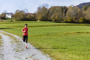 A woman running outdoors in the countryside of Bavarain National Forest Park