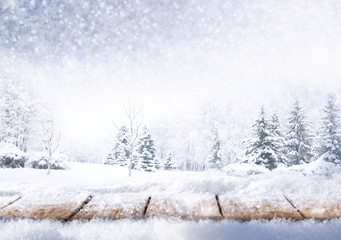 Winter christmas scenic background with copy space. Wooden flooring strewn with snow in forest and landscape with fir-trees covered with snow on nature.