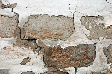Old damaged brick walll with peeling white plaster. Texture.