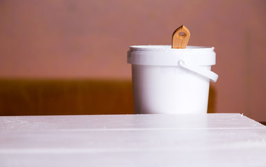 bank with paint and brush stands on a white wooden background.