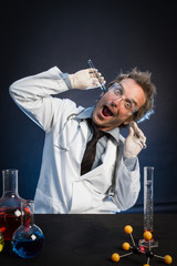Mad Scientist, Wearing Protective Glasses, Holding Test Tubes in His Ears