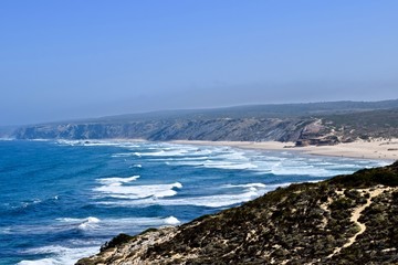 una playa muy larga con olas en Sagres , Portugal 