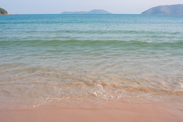 Fototapeta na wymiar Sea water, wave, mountains and sand