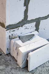 spatula on the foam blocks on the construction of a country cottage
