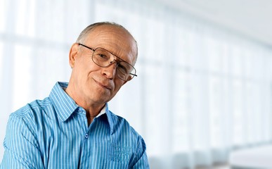 Senior man in blue shirt and glasses