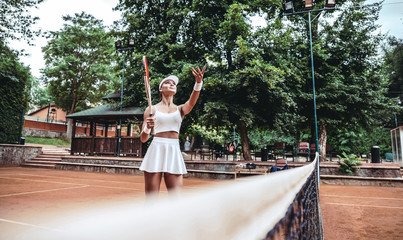 Fototapeta na wymiar Beautiful female tennis player serving outdoor