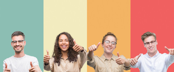 Collage of a group of people isolated over colorful background approving doing positive gesture with hand, thumbs up smiling and happy for success. Looking at the camera, winner gesture.