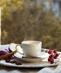 A cup of tea with red apples and cinnamon