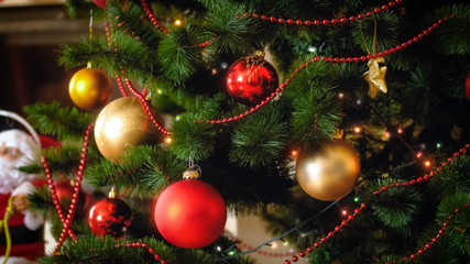 Fototapeta na wymiar Closeup image of beautiful colorful balls and glowing lights on Christmas tree