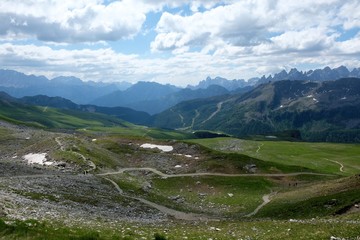 Fototapeta na wymiar paesaggio montagna viaggio turismo estate nubi cielo azzurro prato erba verde cime rocce sentiero