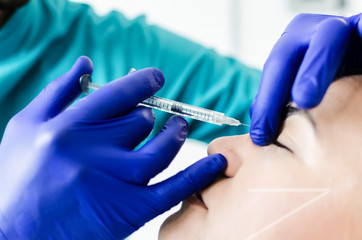 Doctor putting hyaluron on patient's nose
