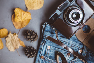 Moscow, Russia - 08 30 2018:top view blue jeans, autumn leaves, Rowan berries, vintage retro camera, card in pocket, copy space