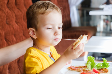 Little boy eating a small pizza