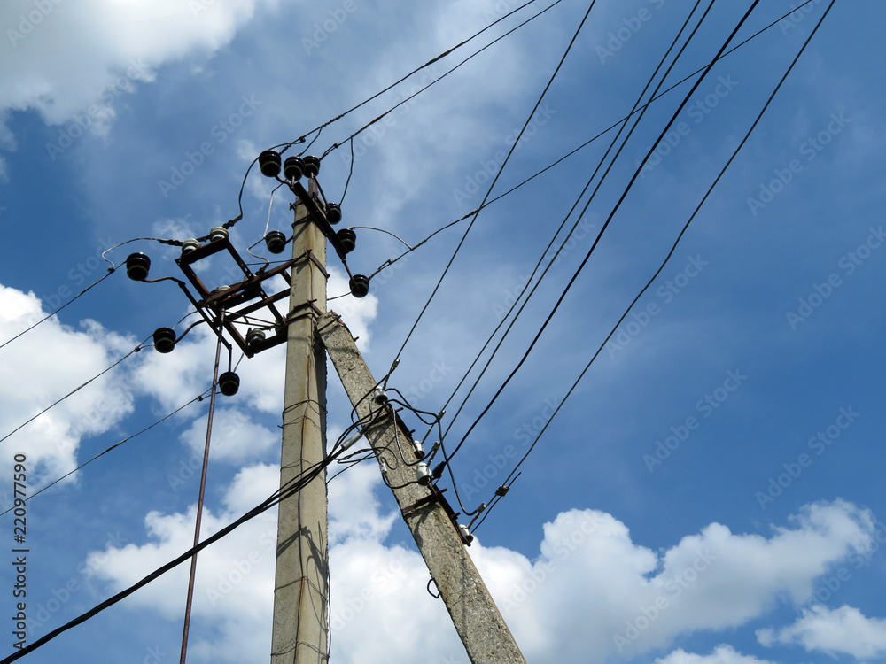 Wall mural power line support against blue sky with white clouds. power pole with electrical wires and capacito