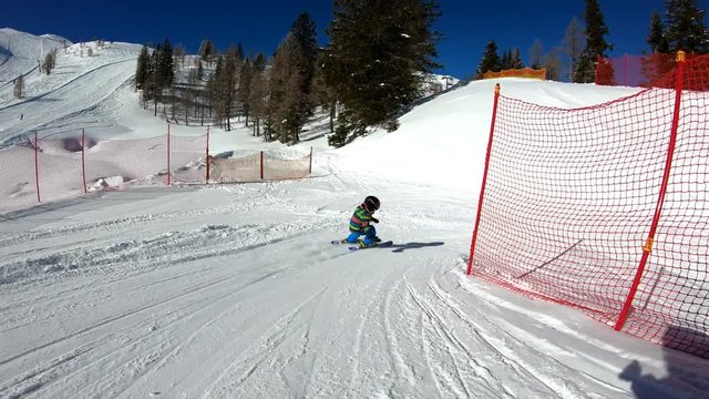 A little boy on a skicross track.
A child enjoys riding on a special track. Stabilized footage.