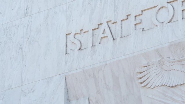 Pan across the text "State Of Oregon" and an eagle, engraved into marble above the main entrance to the Capitol Building in Salem.
