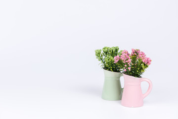 Artificial flowers in green and pink vase on white background