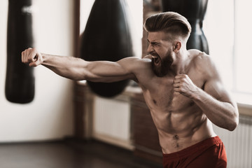 Fototapeta na wymiar Athletic Male Boxer Training at Boxing studio