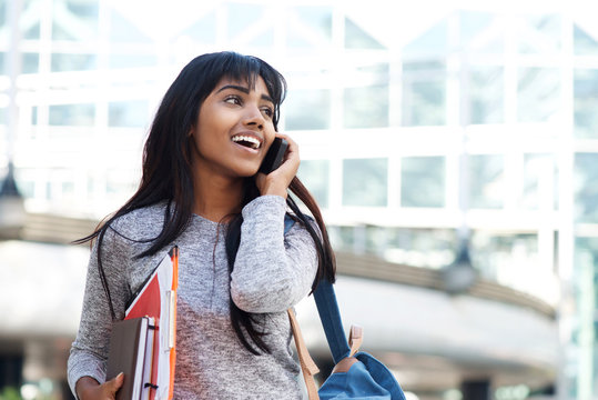 Happy Indian University Student Walking And Talking With Mobile Phone