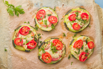 Zucchini small round pizza with pepperoni and tomatoes.