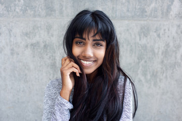 Fototapeta premium young Indian woman smiling with hand in hair