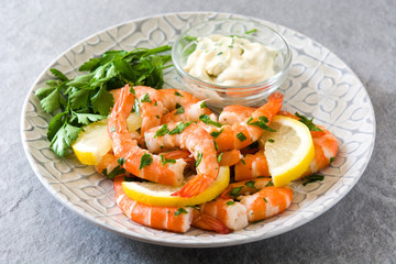 Grilled shrimps, parsley and lemon on gray stone