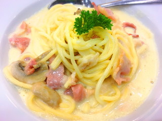 spaghetti carbonara with bacon and cheese on bowl