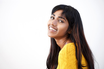 Side portrait of young Indian woman smiling against isolated white background